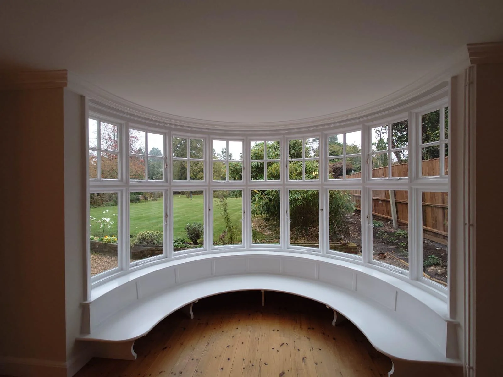 Curved bay window with freshly painted white woodwork and window seat