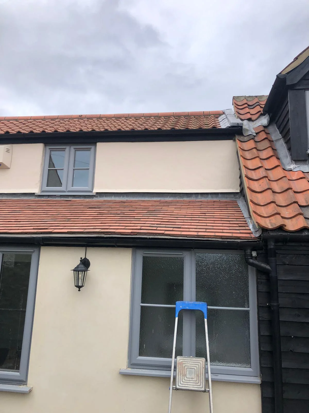 Exterior masonry painting — cream render with grey window frames, Norfolk