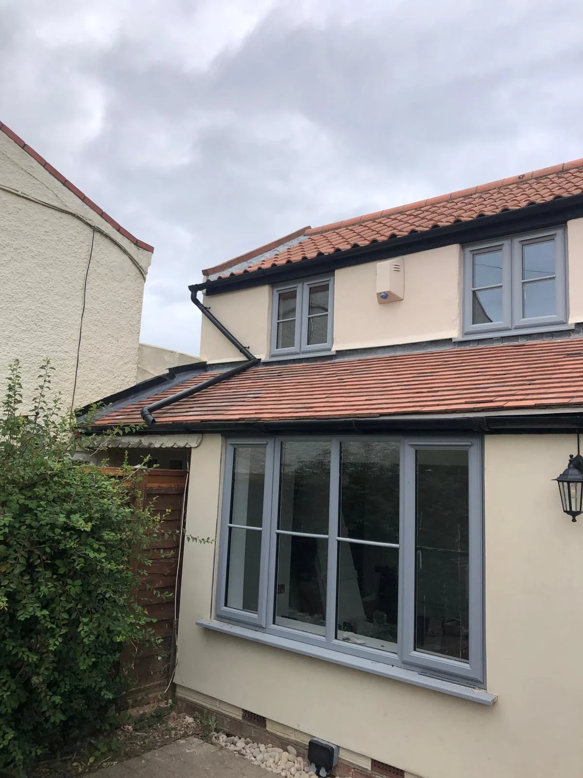 Full exterior repaint with cream masonry and grey UPVC window surrounds