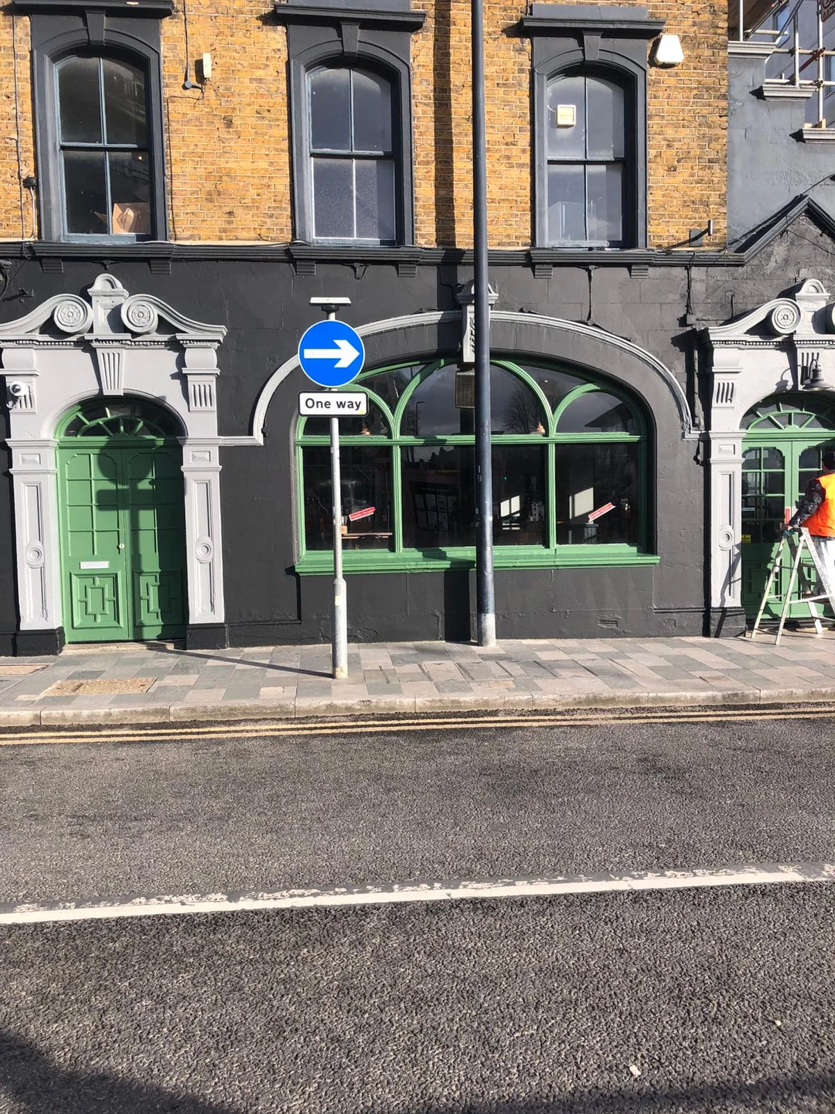 Commercial shopfront painting — black exterior with green doors and frames